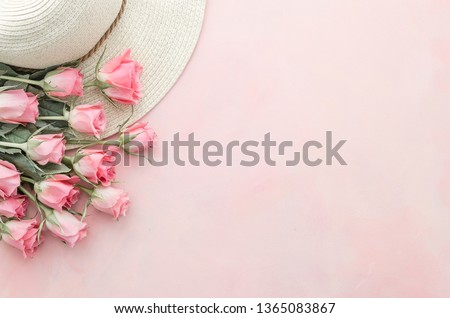 Beautiful flat lay. Pink roses on pastel pink background flat lay. top view of flowers and hat with space for text. Banner mockup with a copy space