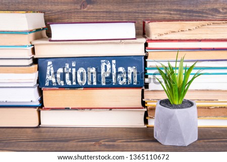 Action Plan concept. Books stacked on a wooden table