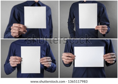 A man in a blue shirt holding a white letterhead