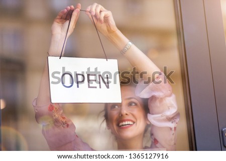 Woman holding open sign in cafe