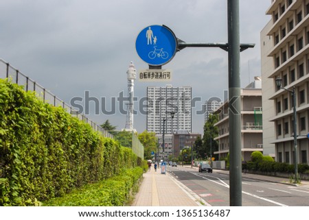 The image of signpost in sidewalk in cloudy sky, Japan.
Translation : Cycling by bicycle is permitted on this sidewalk.