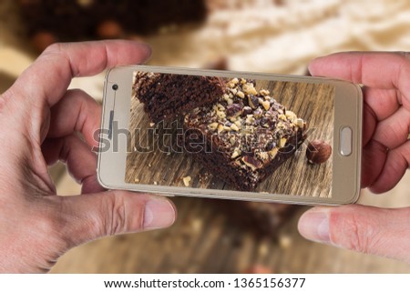 Man taking photo of Cocoa and chocolate brownies dessert with hazelnut