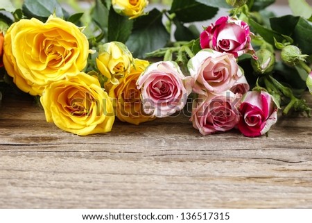 Wooden surface with copy space decorated with colorful roses