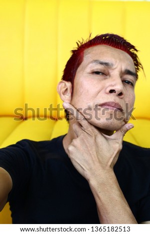 A man looking at camera, red hair dye