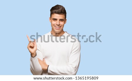 Young authentic man pointing to the side with finger