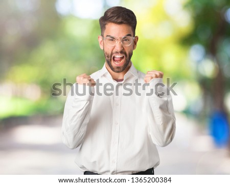 Young handsome business man surprised and shocked