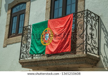 Portuguese flag on the wrought iron railing of stone balcony in an old building at Linhares da Beira. A medieval hamlet with unique architectural diversity fruit of several times, in eastern Portugal.