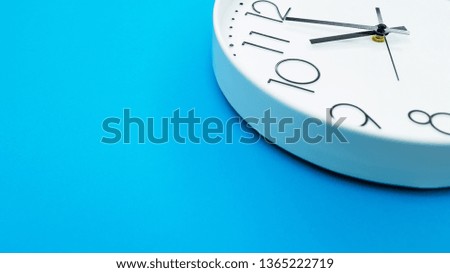 Closeup single clock hanging on blue wall