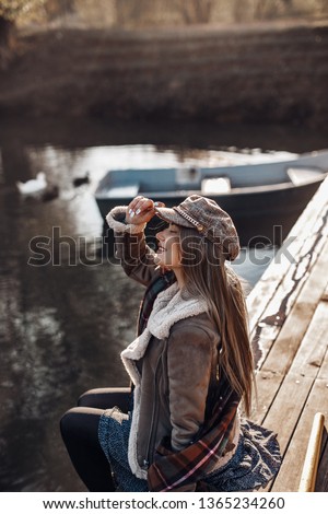Beautiful blond woman on the pier near the pond