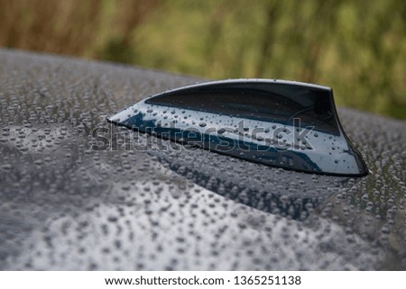 closeup of water droplets on a car fin antenna