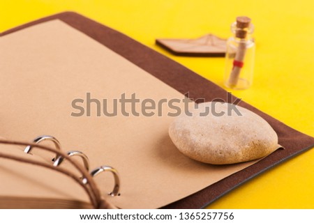 Bright summer holiday background with leather note book, travel and nautical decor on yellow desk