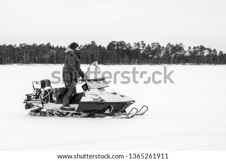 man on a snowmobile black and white photo