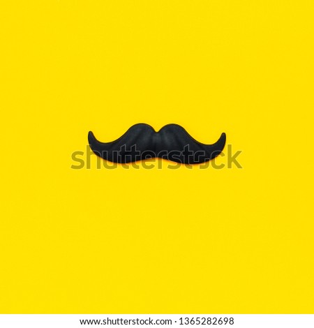 Creative party decoration concept. Black mustache, props for photo booths, carnival, parties on yellow background top view flat lay copy space. Father's day, Men's health awareness month Royalty-Free Stock Photo #1365282698