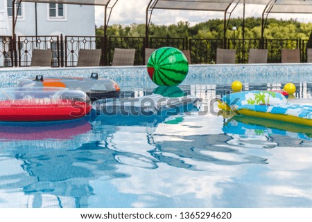 Inflatable water activities, balls, mattresses, circles, tubes float on the water in the pool