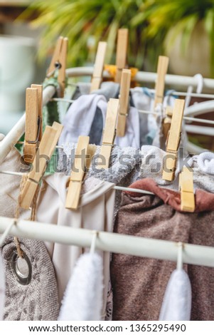 White and colored linen to be dried on the clothesline with wooden clothespins