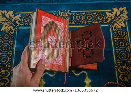 An islamic concept for Ramadhan. Flat lay composition of Qoran, Dates and a tasbih (rosary beads) on top of a sajadah (praying mattress)