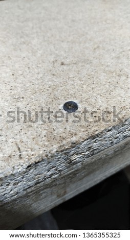 
Fragment of texture chipboard in which the old screw is driven