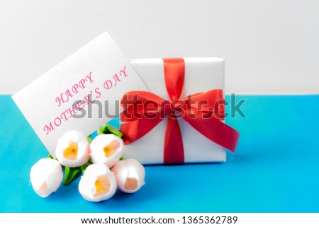 Mother's Day concept. Pink tulips bouquet and a gift on white wooden background, Copy space for card and advertiser.