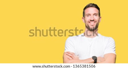 Handsome man wearing casual white t-shirt happy face smiling with crossed arms looking at the camera. Positive person.