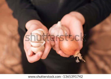 In the hands of the girl there is garlic and onion, good natural remedies for colds. Top view