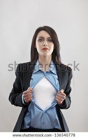 attractive businesswoman pulling her shirt apart doing a superhero businessman poses Royalty-Free Stock Photo #136540778
