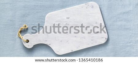 banner of marble cutting board on a blue linen tablecloth. empty form for recipes, restaurants menu Royalty-Free Stock Photo #1365410186