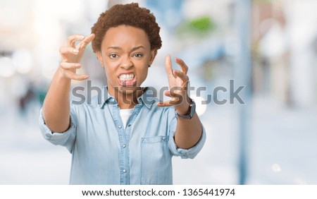 Young beautiful african american woman over isolated background Shouting frustrated with rage, hands trying to strangle, yelling mad