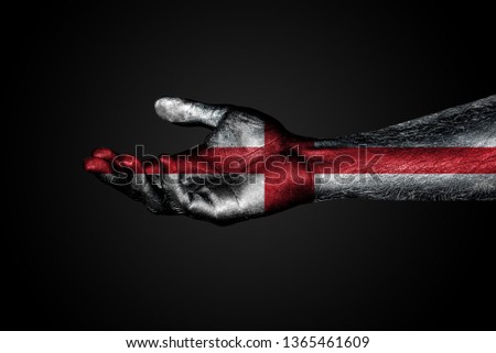 An outstretched hand with a painted flag of England, a help sign or a request, on a dark background. Horizontal frame