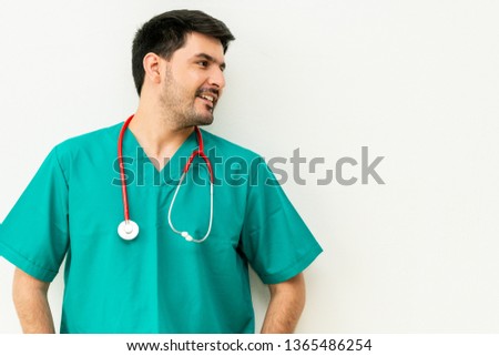 Portrait of young male medical staff in green uniform with stethoscope on white background. Medical healthcare doctor service concept.
