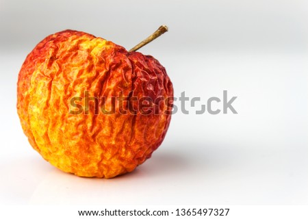 Wrinkled apple texture with white background. Shriveled apple. Old apple.  Royalty-Free Stock Photo #1365497327
