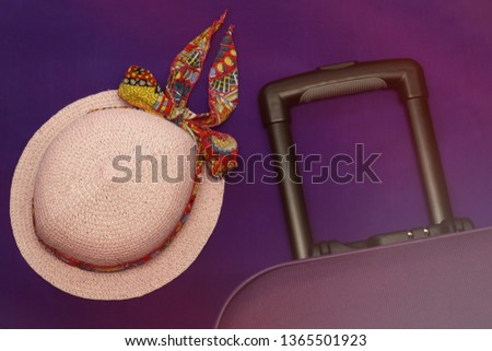 Hat and a suitcase on a lilac background tourism travel hat pink with a bandage fly away on a journey collect things