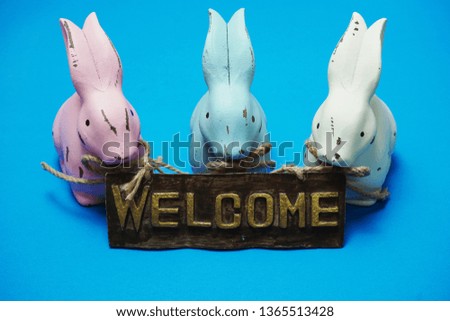 Bunny rabbit with welcome sign on blue background