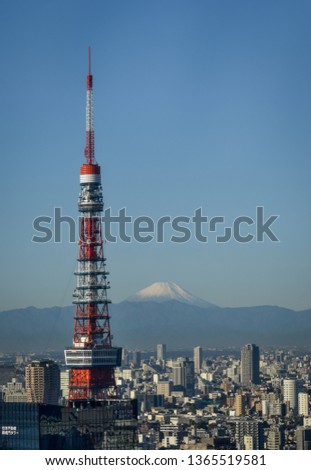 Distant shot of snow-capped Mt Fuji, with the Tokyo tower in the foreground and space for copy