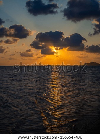 Silhouette of a ferry in the rays against the setting sun with clouds. Koh Phangan Thailand