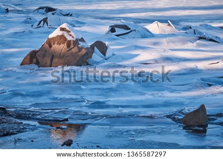 Frozen lake with emerging rock