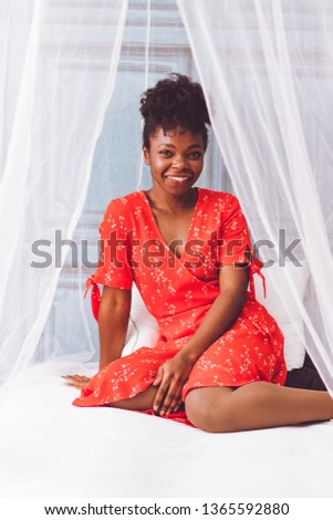 black woman in a bed with curtains mosquito net style boudoir Royalty-Free Stock Photo #1365592880
