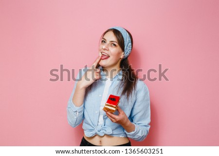 Image of beautiful woman isolated over pink wall background holding cake.