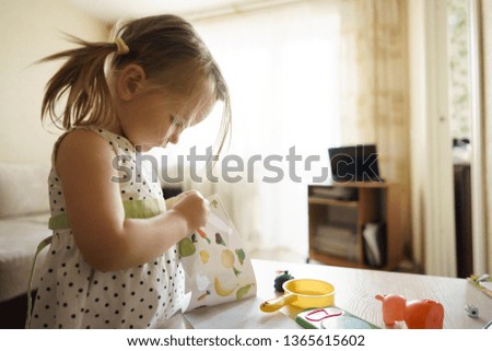 little girl playing at home with toys.