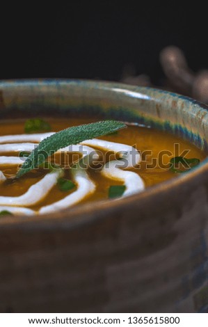 Creamy acorn and sweet potato soup, garnished with Greek yogurt, fresh sage leaves and scallions