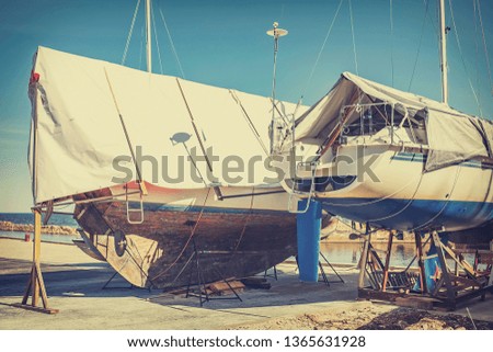 Boats are in the port for restoration. Awning-covered boats in the dock. Vintage photo style.