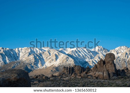rock formations in contrast with snowy Sierra Nevada mountains, Alabama Hills, California, USA