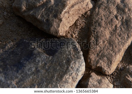 Large brown-gray stones lie on the Ground, close-up, texture
