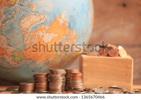 Thai coins stacked on the floor Globe and old wooden floor as background selective focus and shallow depth of field