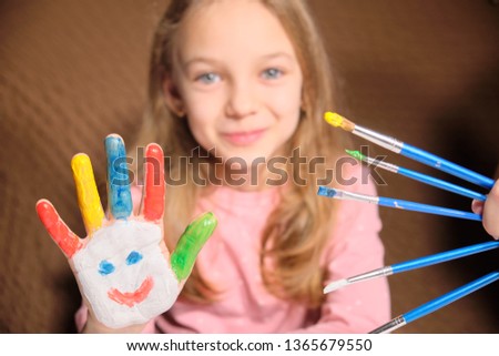 little girl with painted hands finger paint. Painted palms