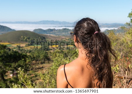 Horizontal picture of long hair woman looking the beautiful valley close to Inle Lake, a touristic destination in Myanmar