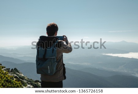 Travel hiker taking photo of majestic mountains range panorama. Carpathian mountains, Ukraine, Europe. Travel background, lifestyle adventure, wide mountains composition