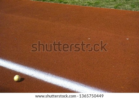  A Baseball lays on a Baseball Field.                               