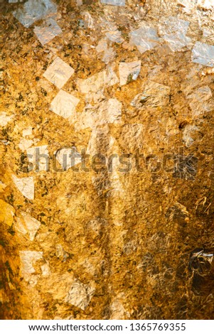 gold leaf background on buddha statue in temple .
