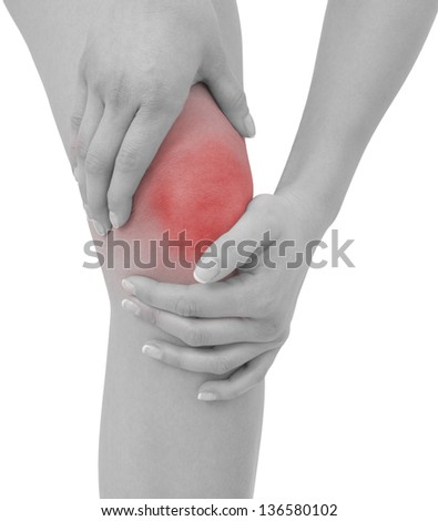 Acute pain in a woman  knee. Female holding hand to spot of knee-aches. Concept photo with Color Enhanced skin with read spot indicating location of the pain. Isolation on a white background.