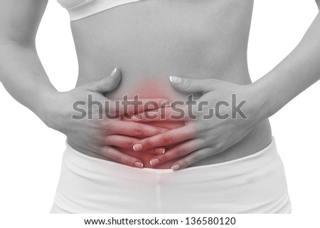 Acute pain in a woman belly. Female holding hand to spot of belly-ache. Concept photo with Color Enhanced skin with read spot indicating location of the pain. Isolation on a white background.
